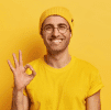 Smiling man in yellow shirt showing OK gesture, positive and friendly.